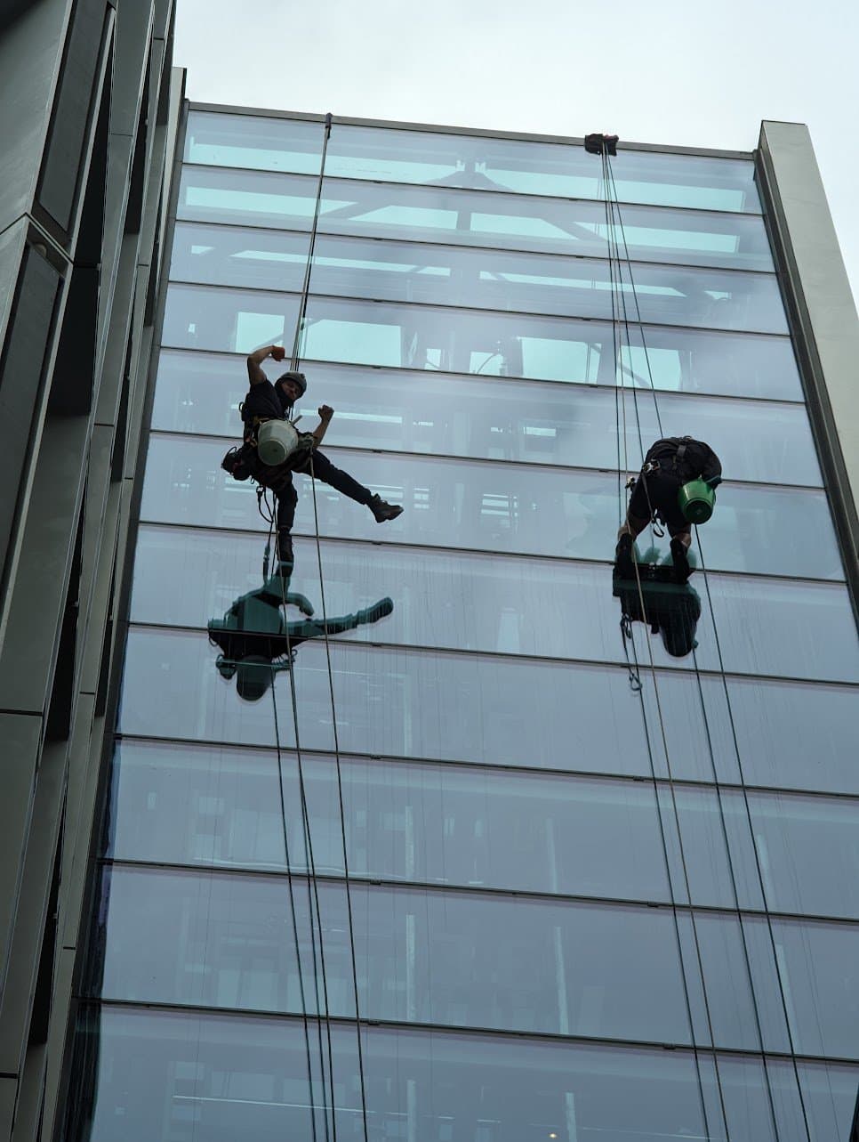 Two Innova rope access technicians cleaning the glazed elevation of a London office building